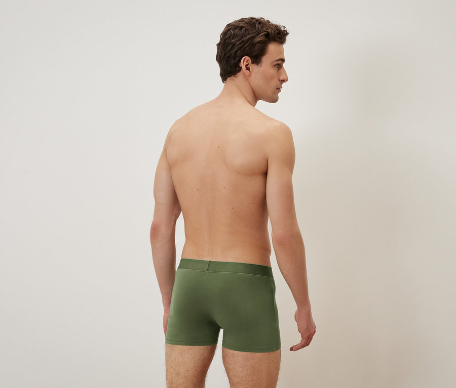 Mann von hinten, trägt grüne Boxershorts.