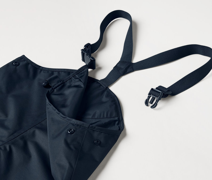 Blaue Schürze mit verstellbaren Trägern und aufgesetzter Tasche, auf weißem Hintergrund.