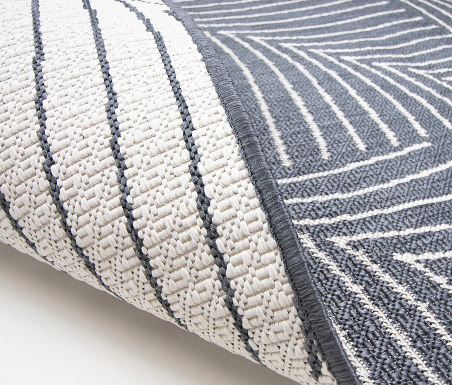 Nahaufnahme einer grau-weißen Teppichrolle mit geometrischem Muster.