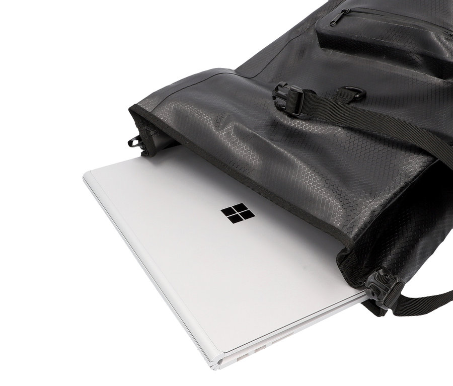 Ein silberner Microsoft Surface Laptop liegt in einem offenen schwarzen Rucksack.