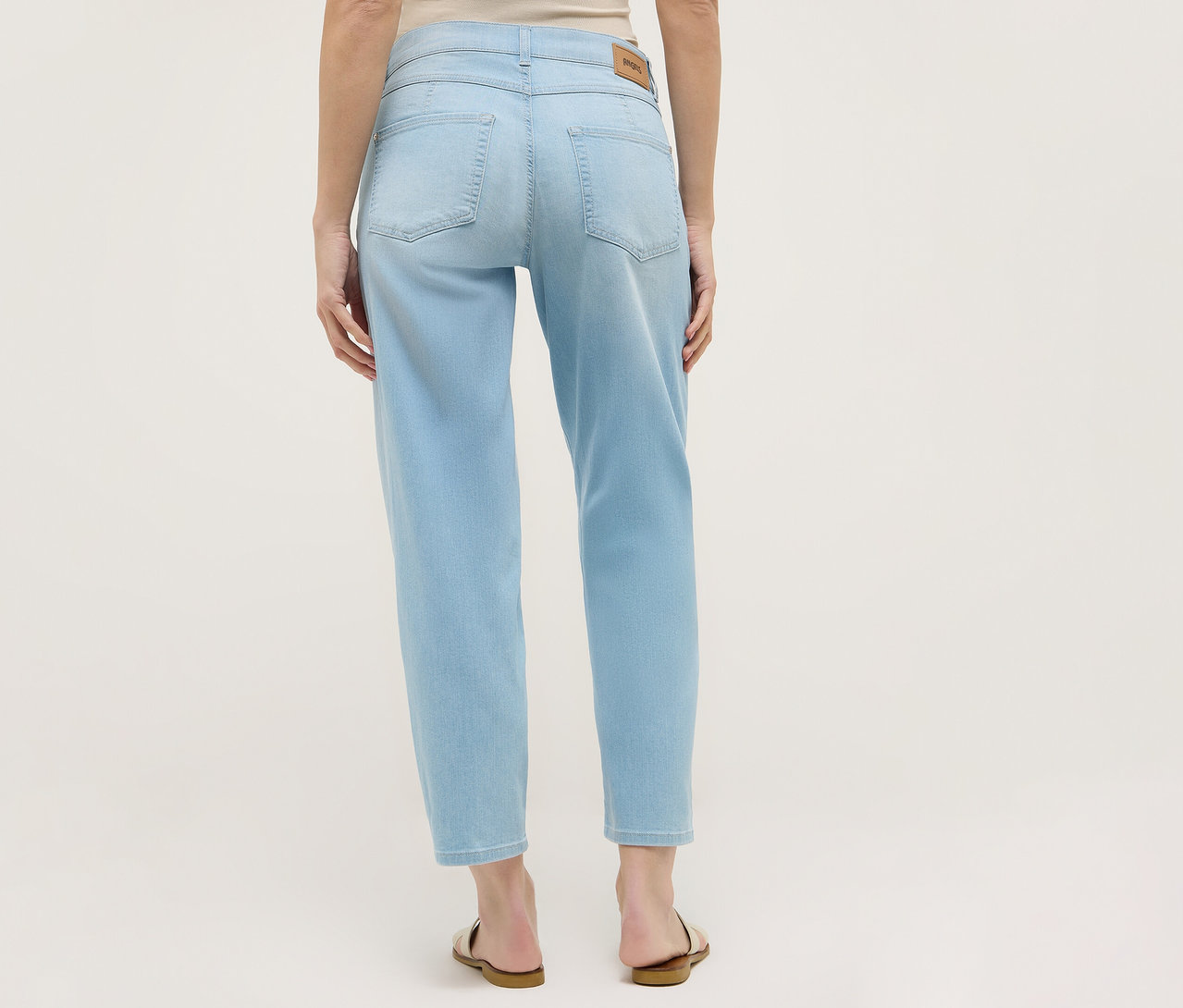 Rückansicht einer Frau in hellblauen Angels Denim »Evy Cool« O-Shape Jeans und Sandalen.