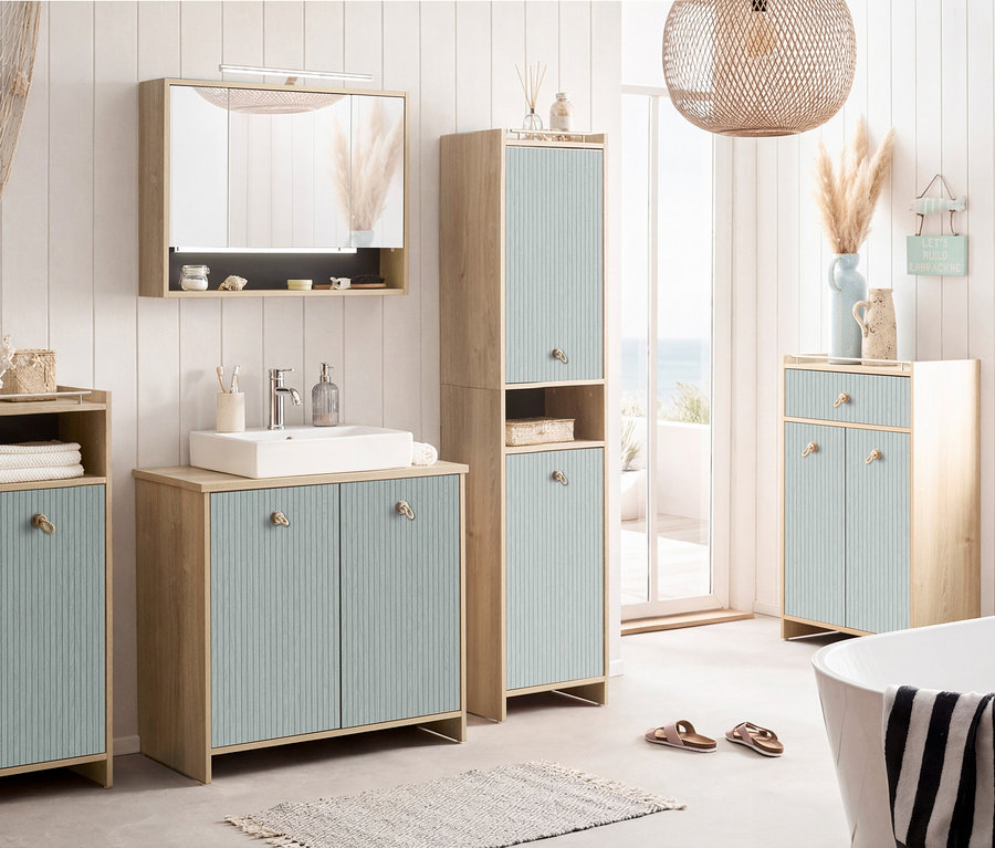 Badezimmer mit Waschtisch, Spiegelschrank, Hochschrank und Kommode in Holzoptik und blau gestreiften Fronten. Badewanne und Deko im Raum.