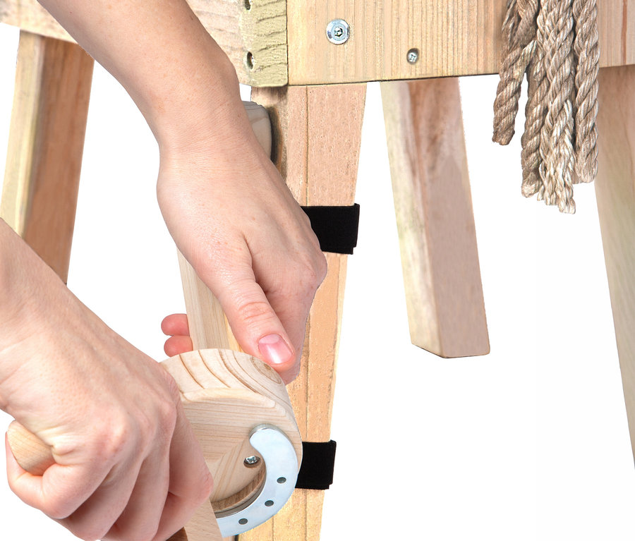 Hände benutzen ein small foot Putzhufe-Set an einem Holzpferd.