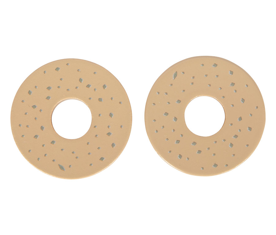 Zwei runde, beige small foot Pferdefutter-Set-Teile mit Löchern in der Mitte und kleinen, dunkleren Flecken liegen nebeneinander.