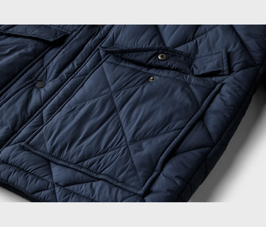 Dunkelblaue, gesteppte Jacke mit Rautenmuster und aufgesetzten Pattentaschen mit Druckknöpfen.