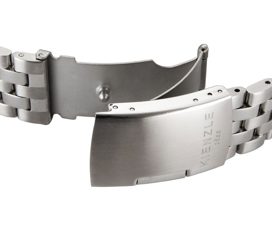 Nahaufnahme eines geöffneten silberfarbenen Metallarmbands einer Uhr mit Faltschließe. Auf der Schließe ist 'KIENZLE 1822' eingraviert.