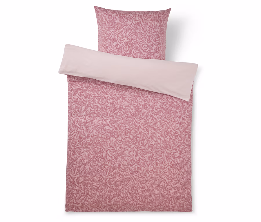 Rosa Bettwäsche-Set mit gemustertem Bettbezug und Kissenbezug, mit einem dunkleren rosa Blattmuster auf einer Seite und einer einfarbigen hellrosa Rückseite.