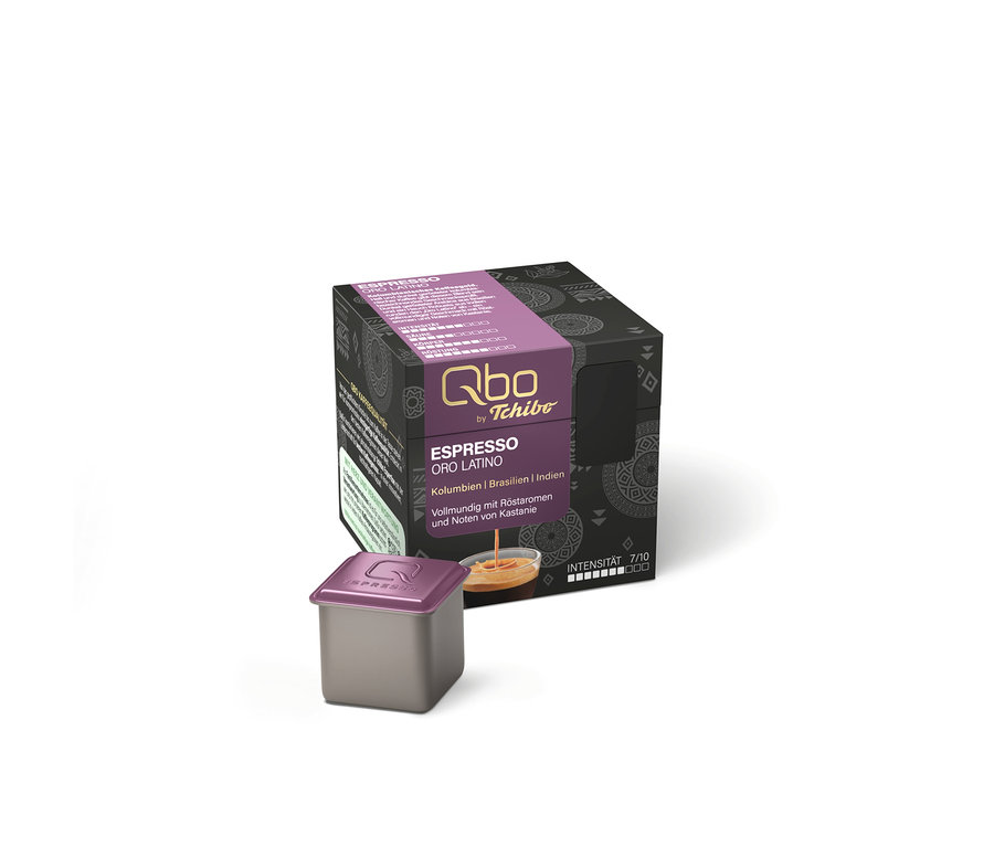 Eine einzelne Qbo Espresso ORO TOLIMA Kaffeekapsel, dunkelgrau mit lila Deckel, vor ihrer dunkelgrauen Box mit lila Band, "Espresso Oro Latino" Aufschrift, Kaffeetasse und Intensität 7/10.