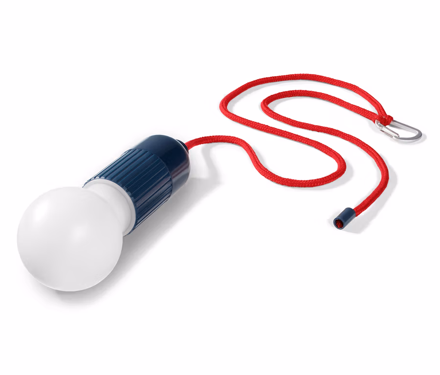 Eine LED-Lampe mit Karabiner liegt auf einem weißen Hintergrund.