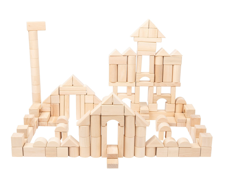 Eine komplexe Struktur aus hellen Holzbausteinen, die einer Burg oder Festung ähnelt. Sie weist mehrere Türme, Mauern und Torbögen auf, mit verschiedenen Bausteinformen wie rechteckigen, zylindrischen, dreieckigen und gewölbten Teilen.