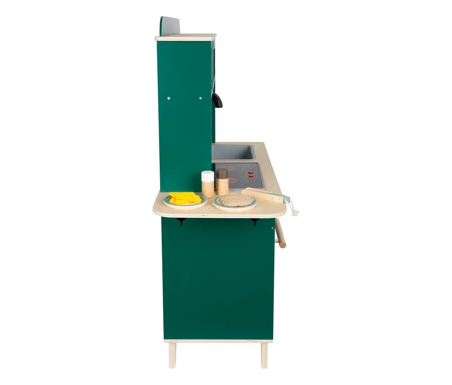 Eine grüne small foot Kinderküche aus Holz mit Spüle, Herdplatten, zwei Tellern mit Spielessen, Gewürzstreuern und einem Pfannenwender.