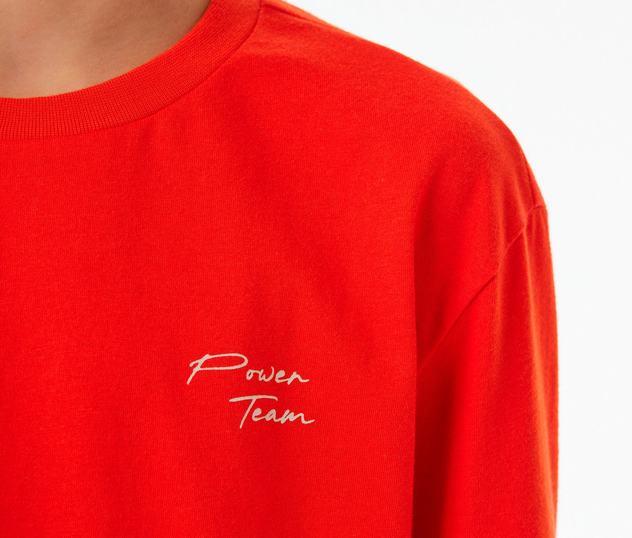 Rotes SCHIESSER Kinder-Pyjama-Oberteil mit Bündchen und der Aufschrift „Power Team“ auf der Brust.