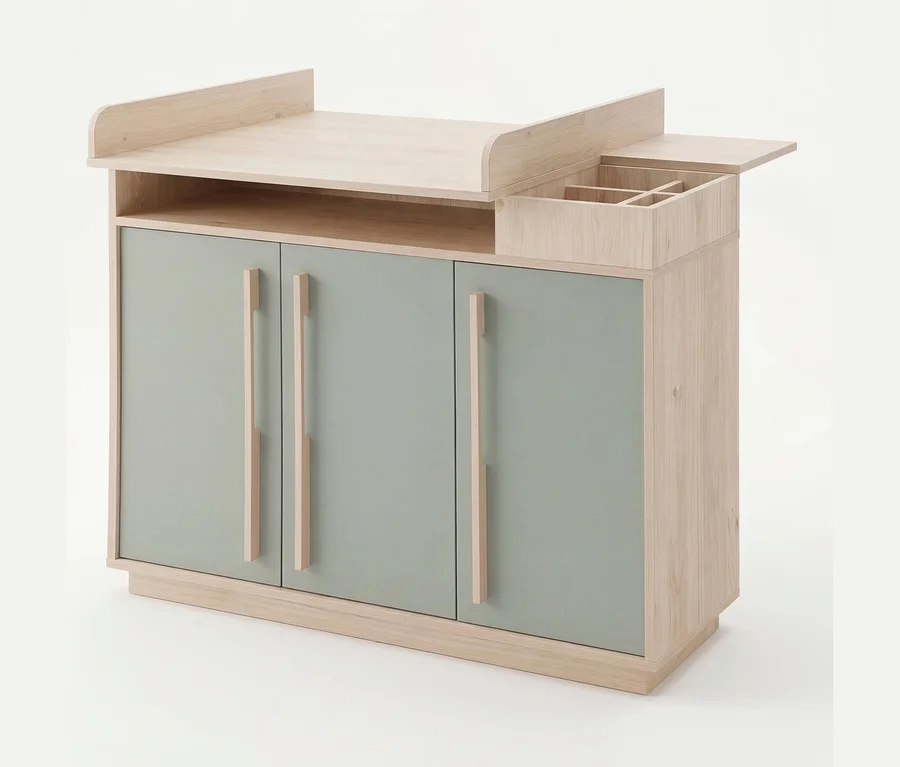 Helle Holzkommode mit drei salbeigrünen Türen und langen Holzgriffen. Oben befindet sich ein Wickelaufsatz mit erhöhten Kanten und einem kleinen Fach mit Unterteilungen.