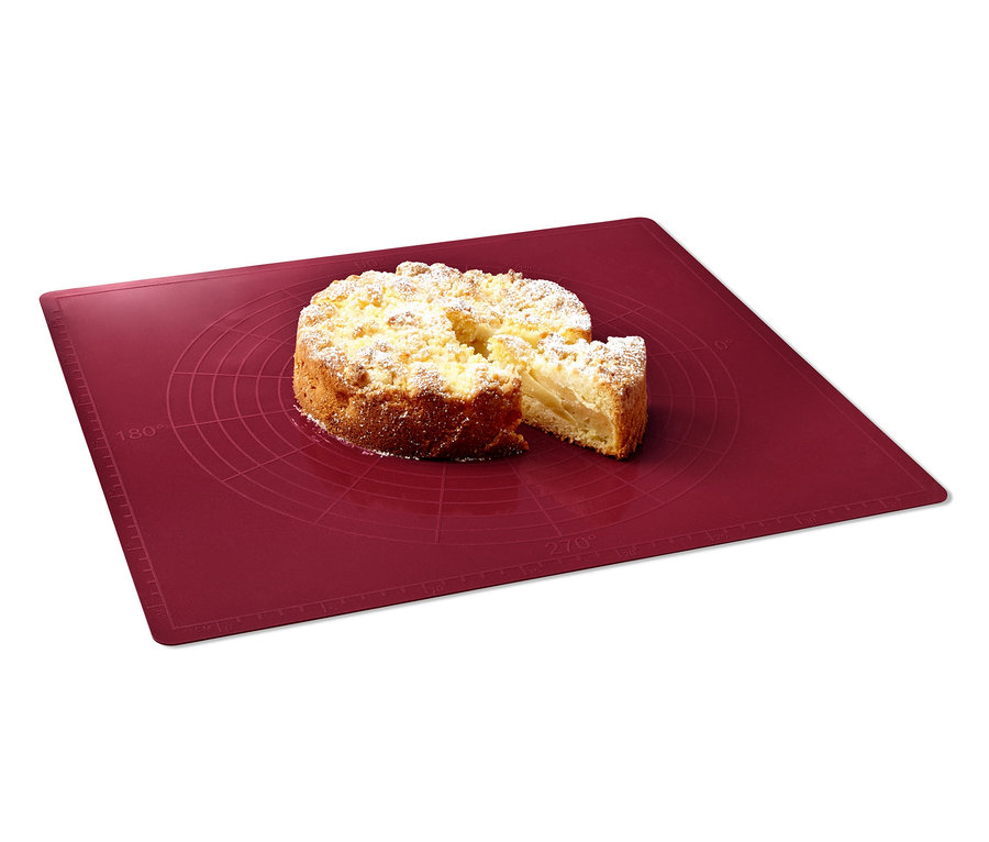 Ein Kuchen liegt auf einer roten Dauerbackmatte.