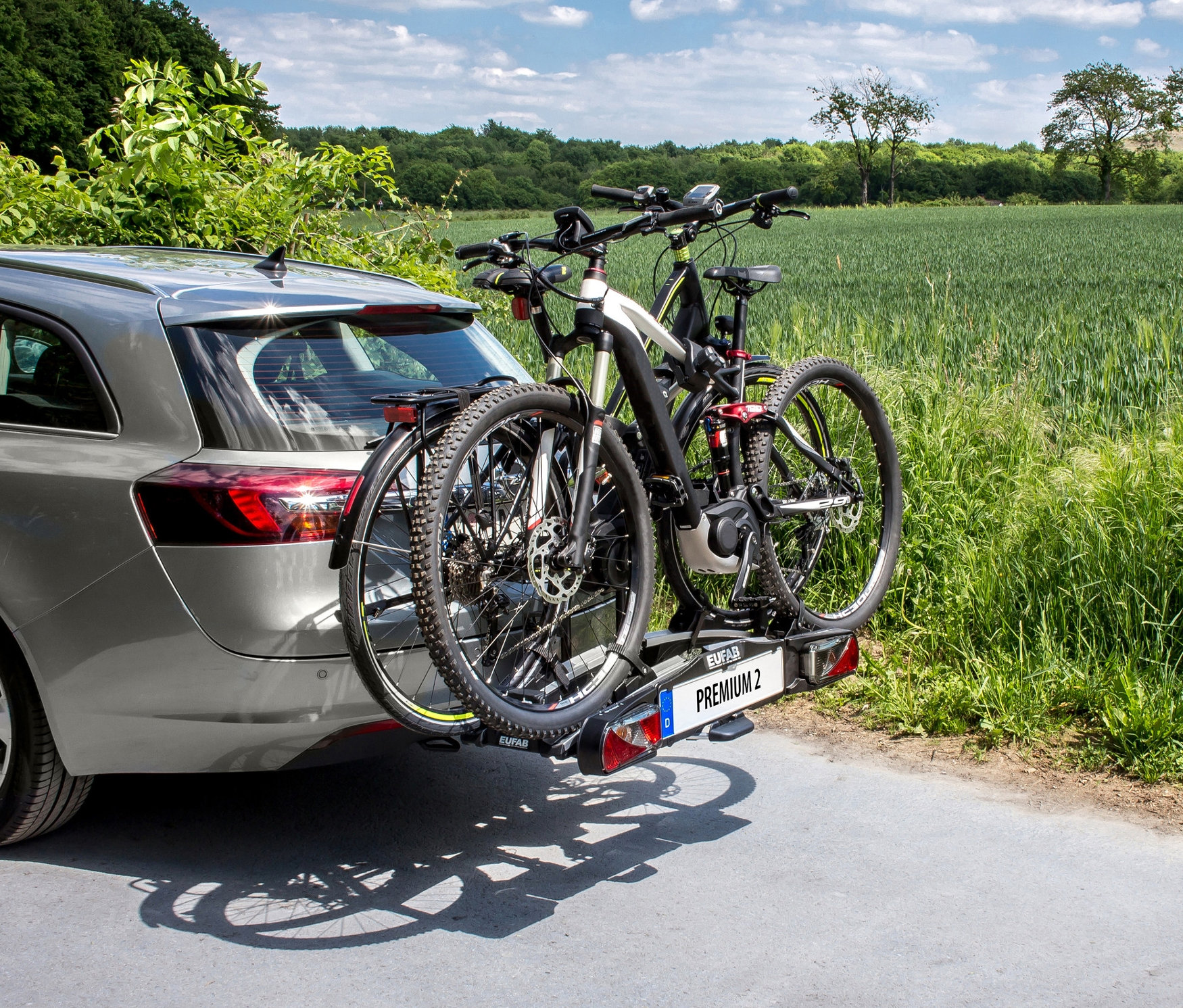Grauer Kombi mit schwarzem Fahrradträger »Premium 2« mit zwei Fahrrädern.