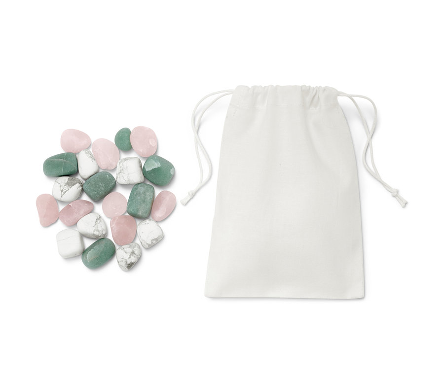 Wasser-Steine liegen neben einem weißen Stoffbeutel.