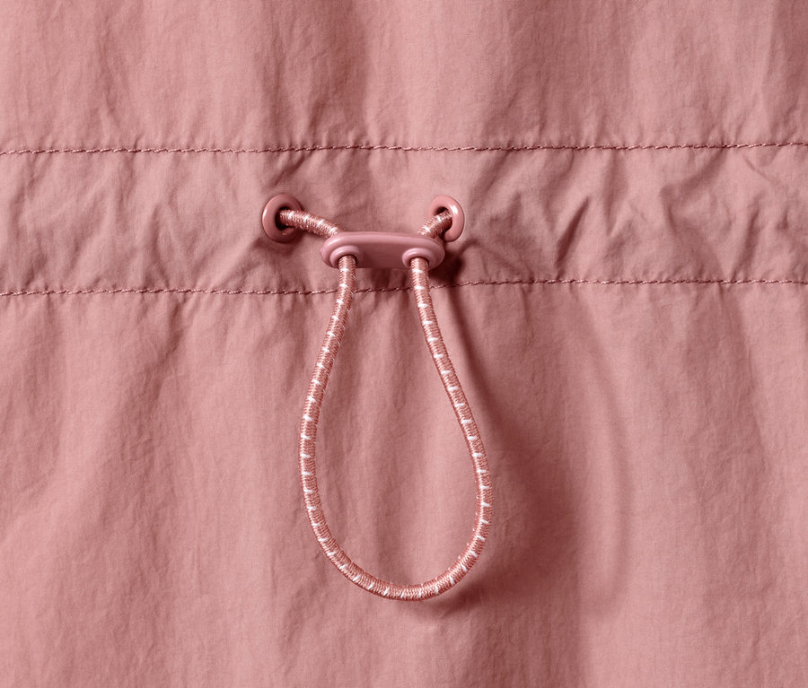 Detailansicht einer rosafarbenen Lightweight-Parka mit Kordelzug.