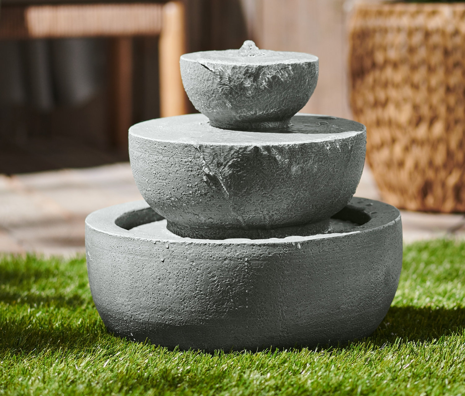 Solar-Gartenbrunnen mit drei Ebenen auf Rasen.