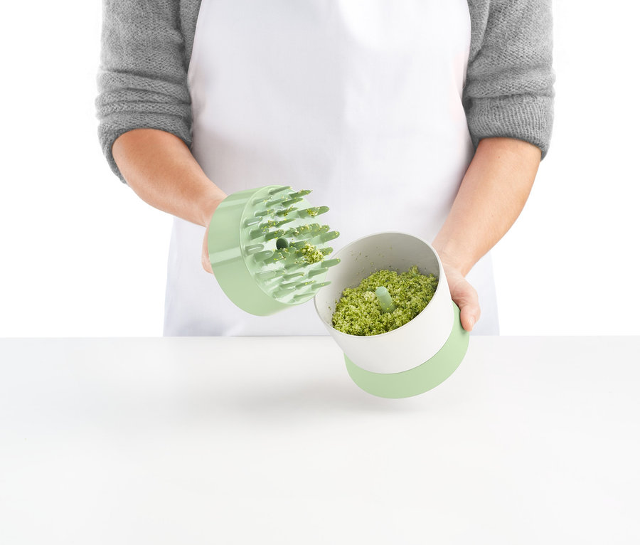 Person hält Veggie-Ricer mit geschnittenem Gemüse.