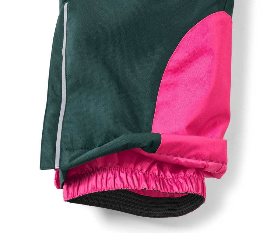 Detail einer dunkelgrünen Kinder-Skihose mit pinkfarbenem Einsatz am Bein und elastischem Saum.