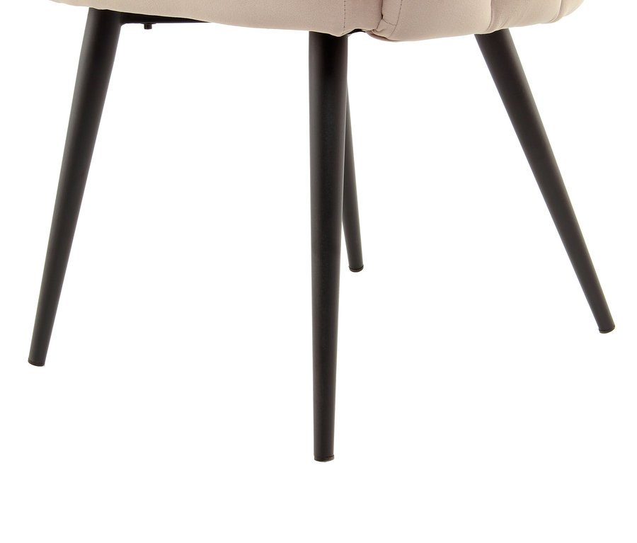 Detailaufnahme eines beigen Kayoom Stuhls »Jeane« mit schwarzen Beinen vor einem weißen Hintergrund.