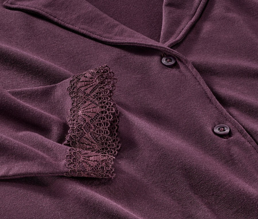 Detailansicht eines violetten Pyjamas mit Spitze am Ärmel.