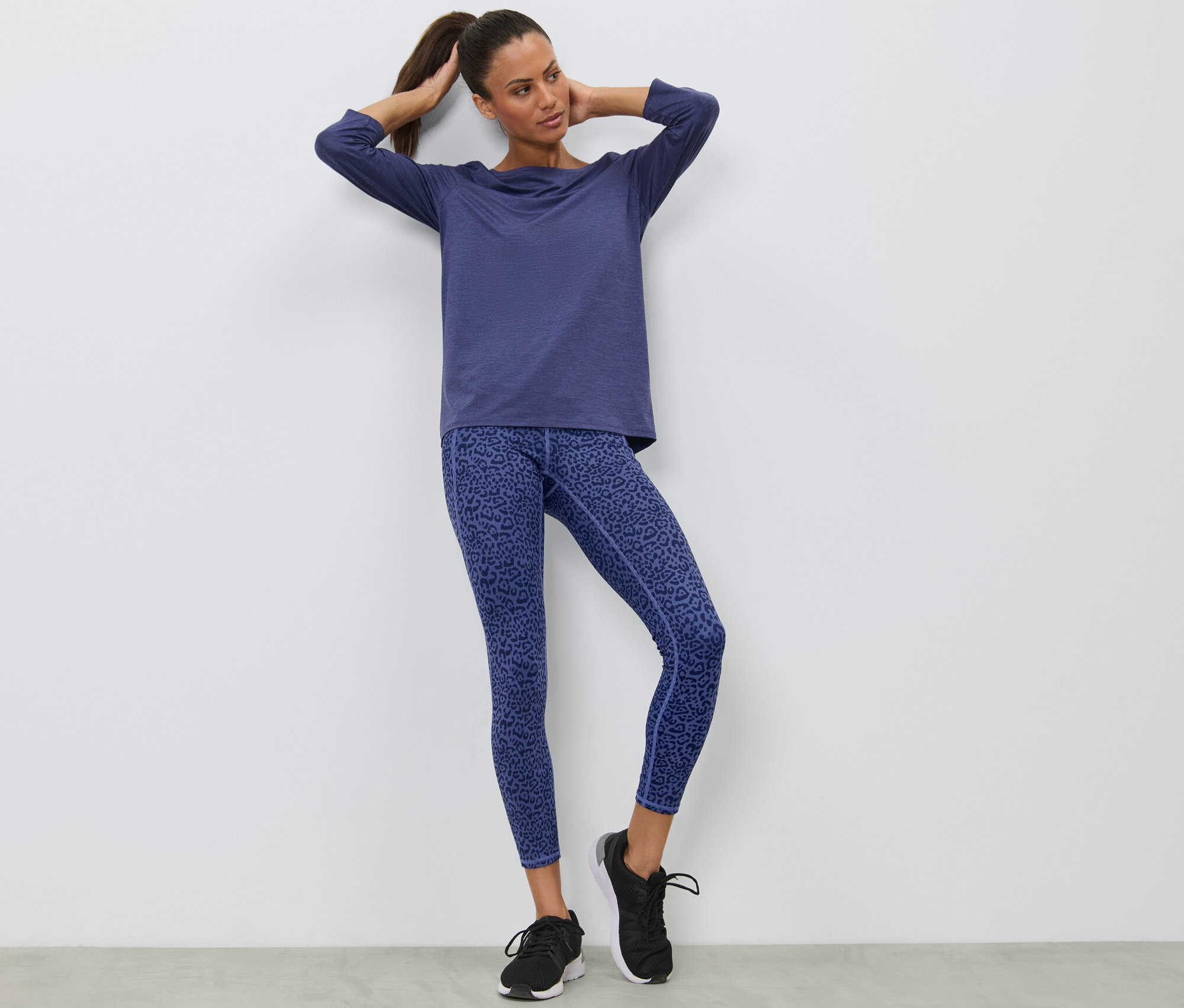 Frau posiert in lila Sporttight.