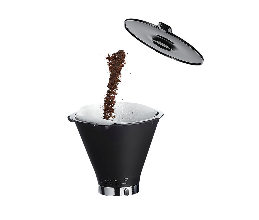 Kaffee wird in eine schwarze Kaffeemaschine mit Filter und grauem Deckel darüber gegossen. Wilfa Kaffeemaschine »Svart Precision«.