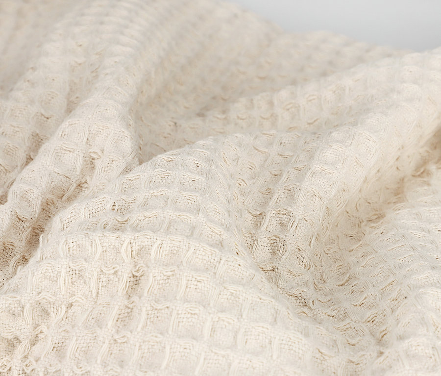 Nahaufnahme einer beigen SCHÖNER WOHNEN Wohndecke.