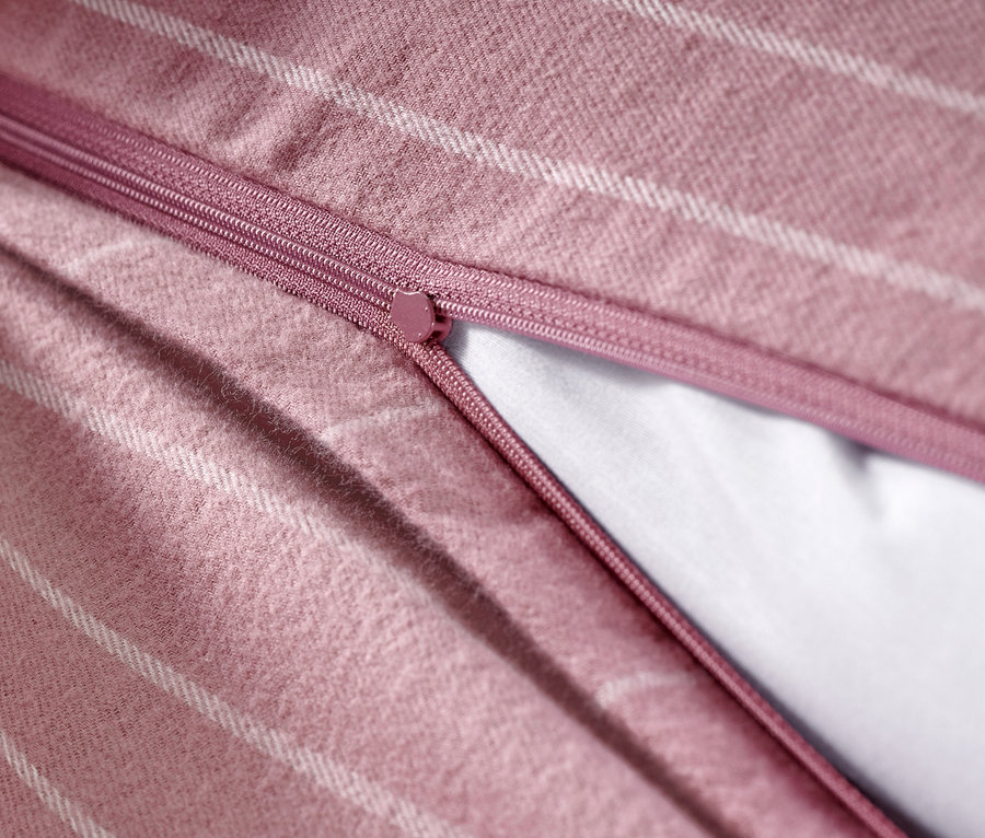 Nahaufnahme von Flanell-Bettwäsche mit Streifenmuster und teilweise geöffnetem Reißverschluss.