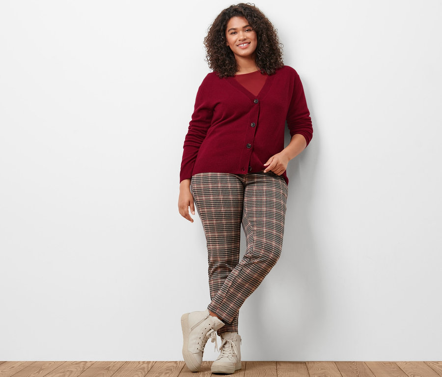 Frau posiert in Strickjacke mit Cashmere, bordeauxrotem Shirt mit 3/4-Arm und Joggpants, Hahnentritt-Dessin.