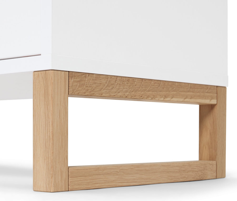 Detailaufnahme eines Sideboards mit 2 Schubladen und 2 Türen, weißer Schrank mit Holzfüßen.