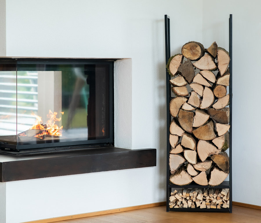 Kamin mit Feuer neben Stahl-Kaminholzregal "Porthos".