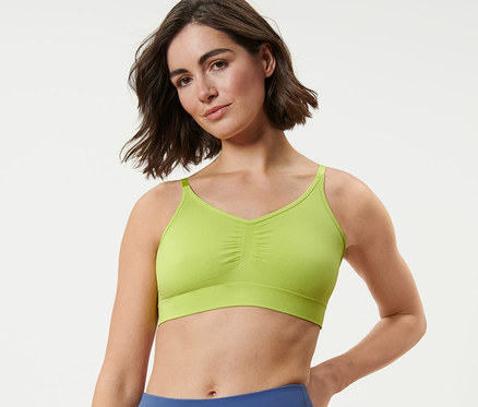 Frau trägt ein Seamless-Sport-Bustier und blaue Leggings.