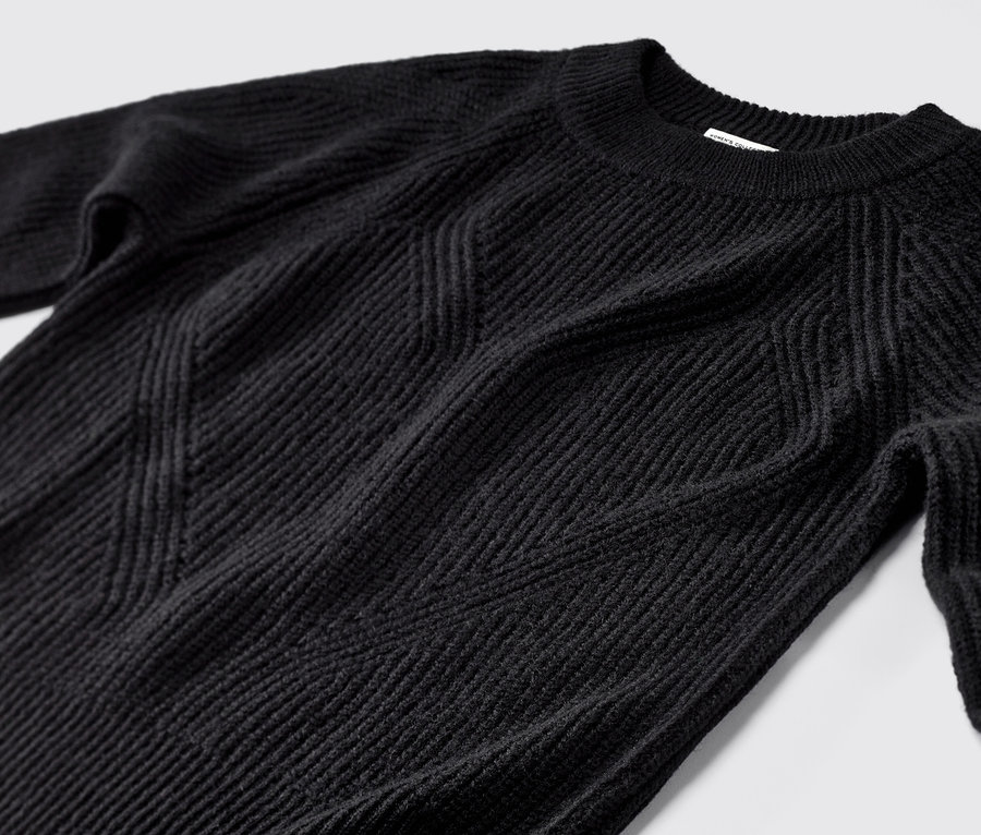 Detailaufnahme eines schwarzen Strickpullovers.