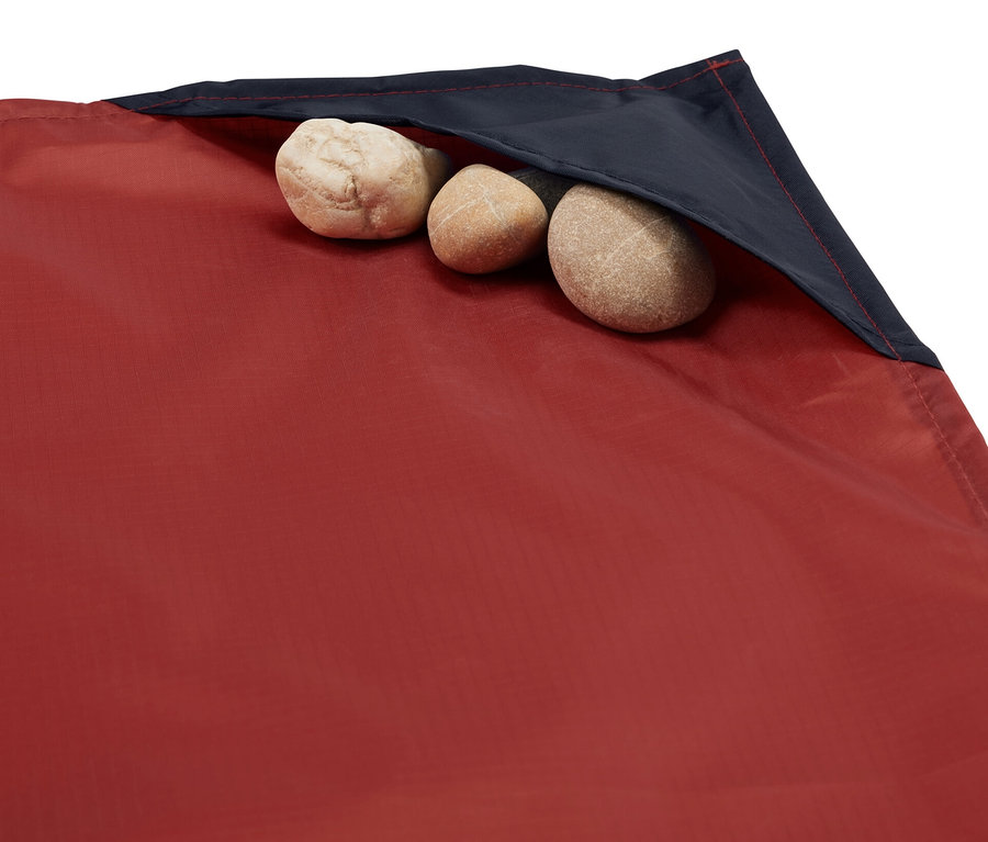 Detailaufnahme einer Mini-Picknickdecke, in deren Tasche drei Steine liegen.