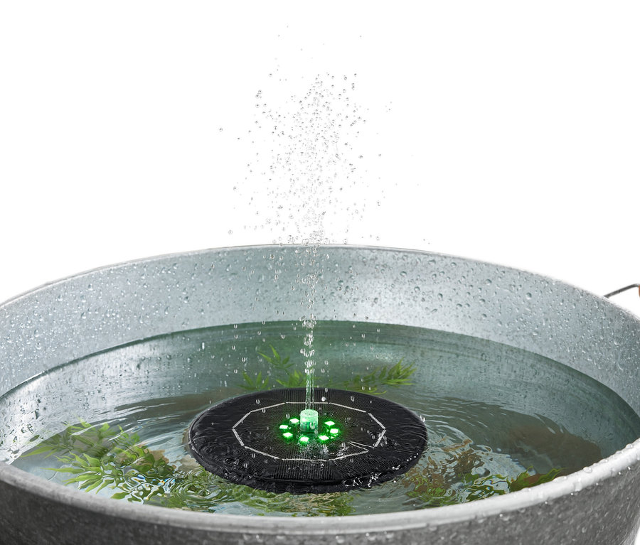 Schwimmender Solar-Springbrunnen mit Beleuchtung im Wasser in einem Metalleimer.
