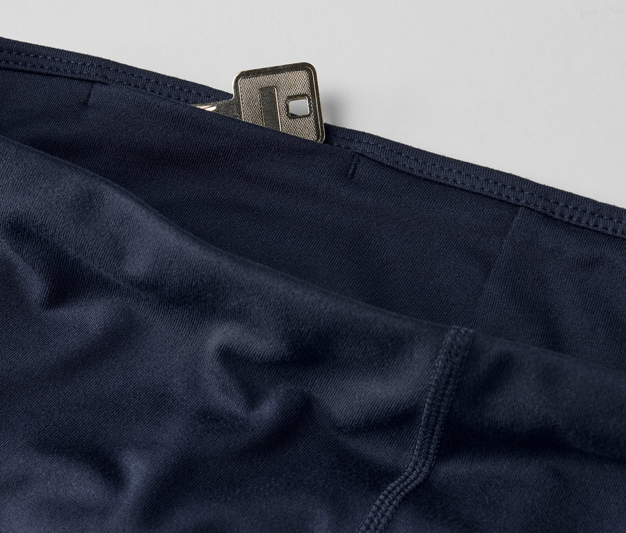 Detailaufnahme einer dunkelblauen 3/4-Sporttight mit einem Schlüssel in der Tasche.