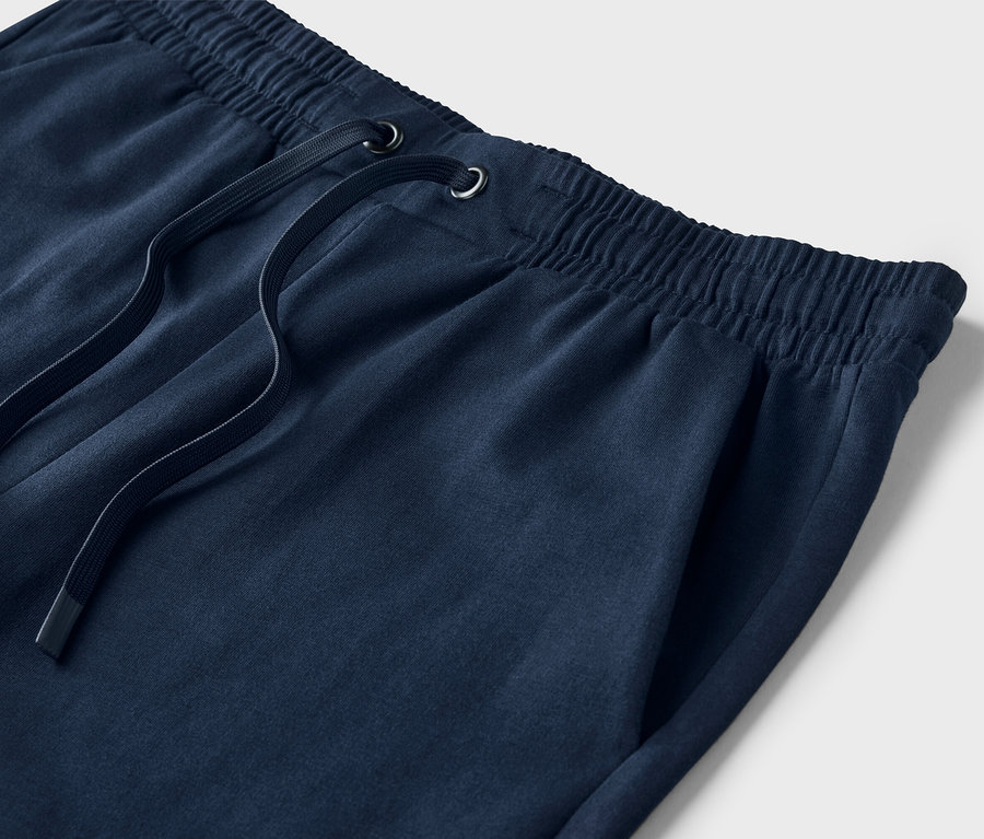 Detailaufnahme von dunkelblauen Sweatshorts mit Kordelzug und Tasche.