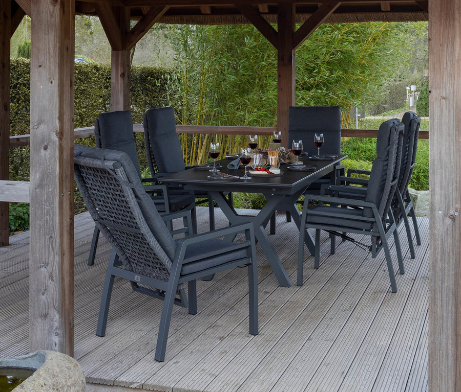deVries Dining-Set, steingrau-rope unter einem Reetdach. Auf dem Tisch stehen Gläser und Snacks.