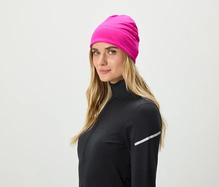 Blonde Frau trägt ein schwarzes Sportoberteil und eine pinke Mütze.