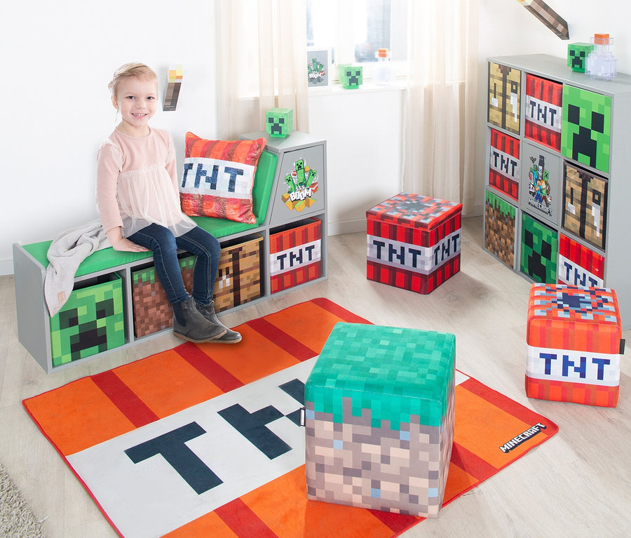 Mädchen sitzt auf einer grauen Bank mit Minecraft-Motiv-Aufbewahrungsboxen in einem Kinderzimmer. 2 roba Minecraft Sitzhocker sind sichtbar.