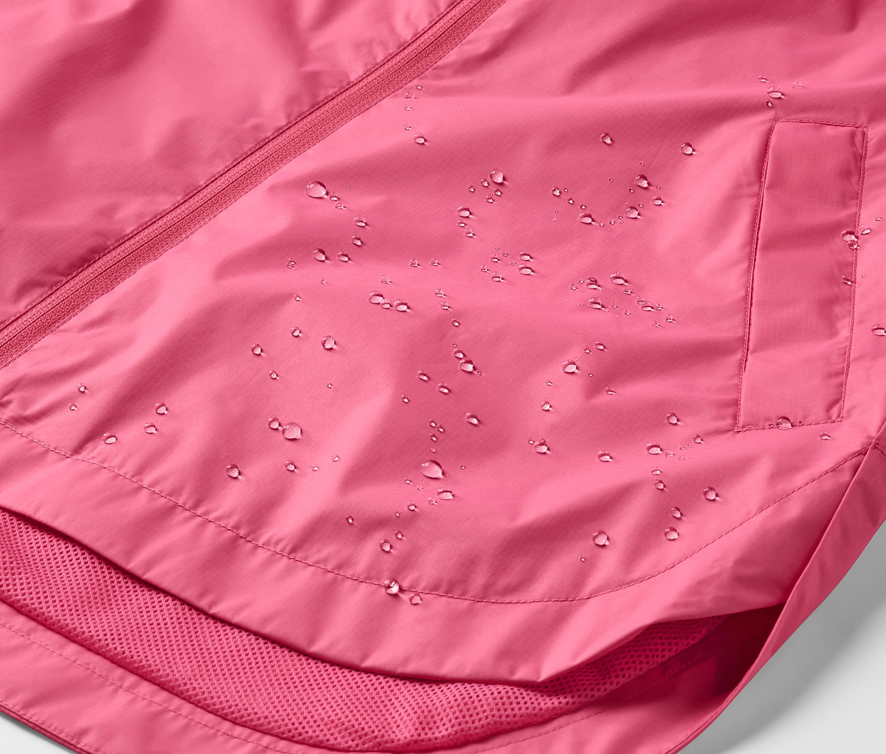 Detailaufnahme einer pinken Regenjacke mit Wassertropfen.
