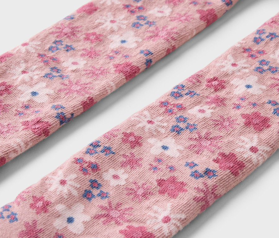 Detailaufnahme von drei Paar Kinderstrumpfhosen mit Blumenmuster.