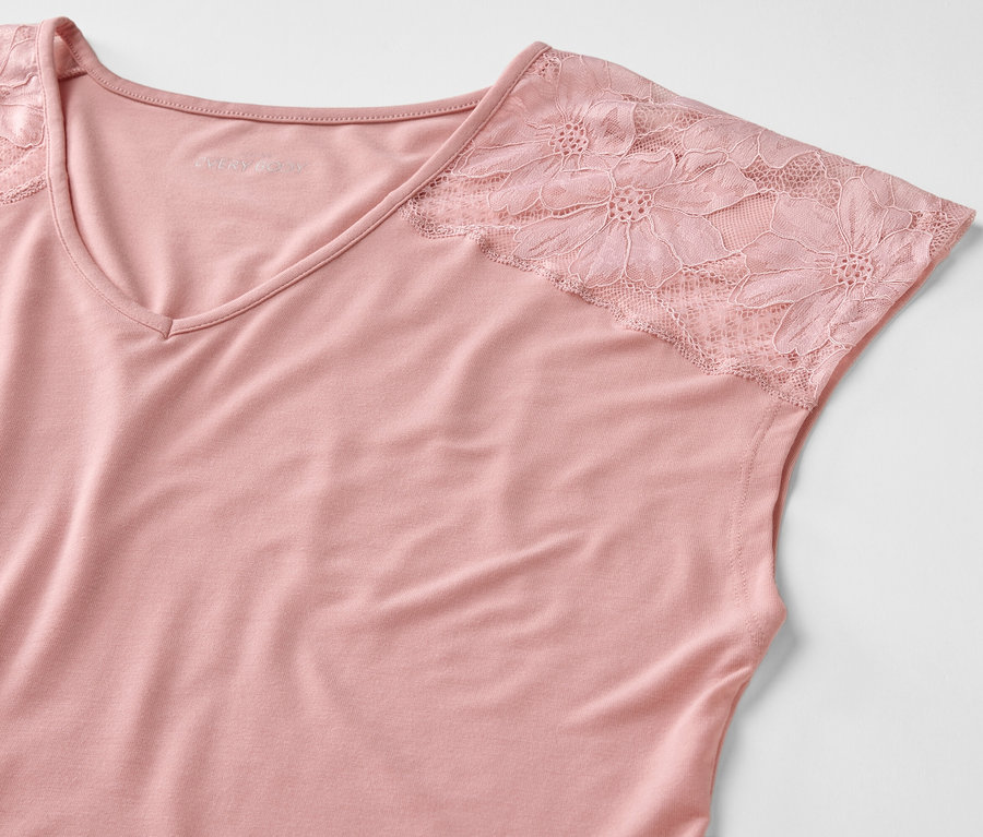 Detailaufnahme eines rosafarbenen Tops mit Spitzenärmeln.