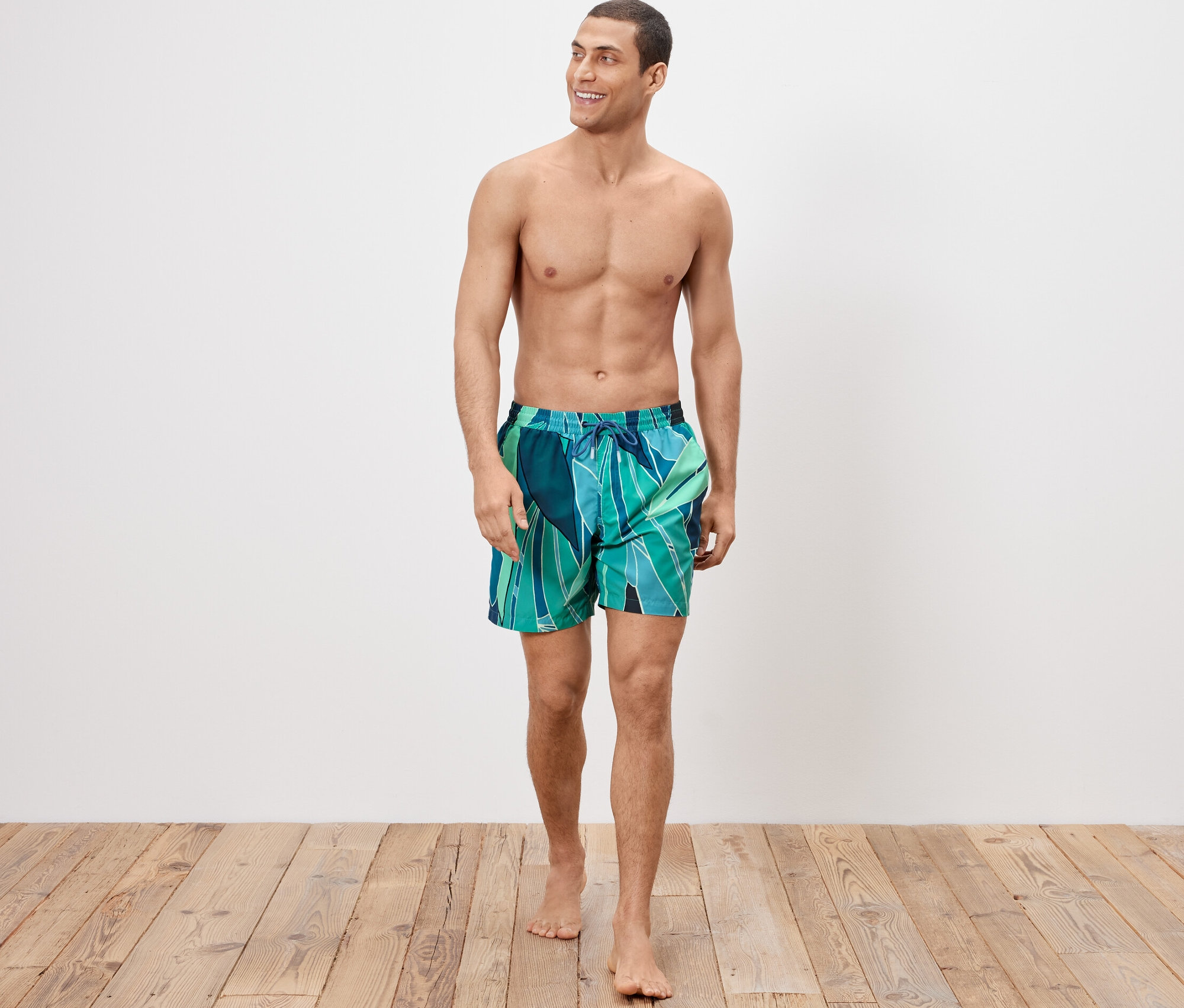 Mann trägt Badeshorts und geht.