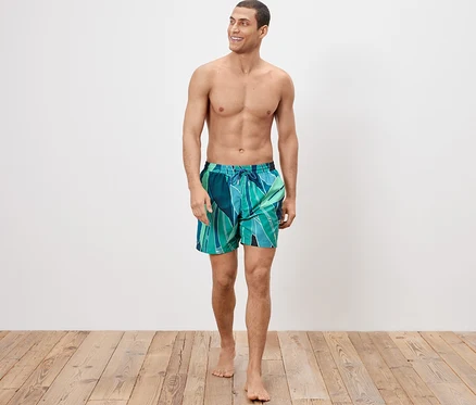 Mann trägt Badeshorts und geht.