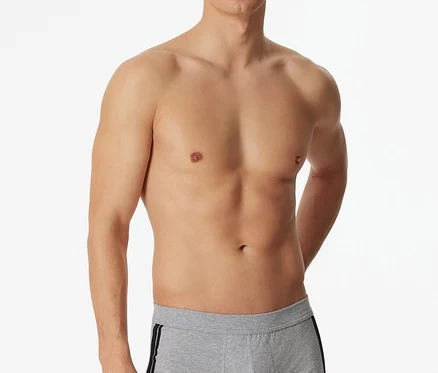 Hemdloser Mann trägt eine graumelierte SCHIESSER Short mit dunklem Seitenstreifen.
