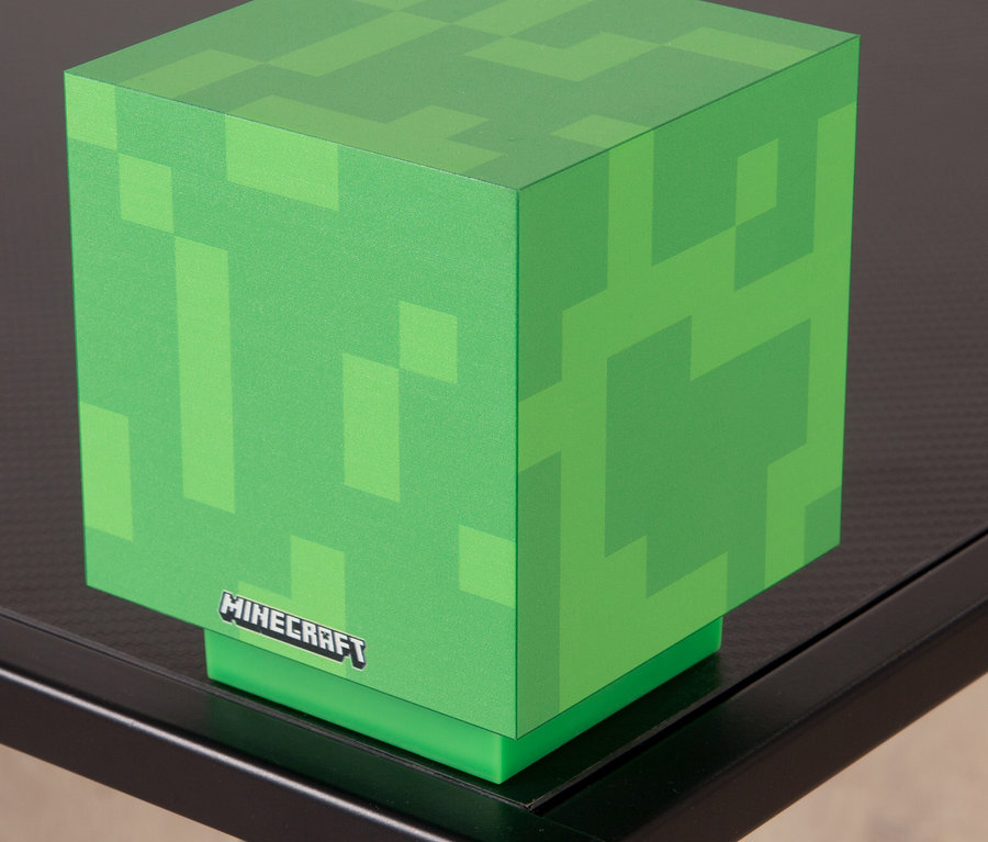 Eine Minecraft LED Dekoleuchte, Creeper, steht auf einem schwarzen Tisch.