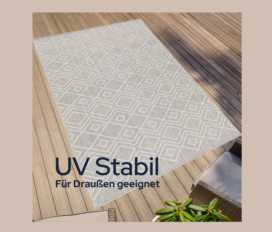 Ein grauer, faltbarer Outdoor-Teppich "Diamond Rhythm" mit geometrischem Muster liegt auf einer Holzterrasse.